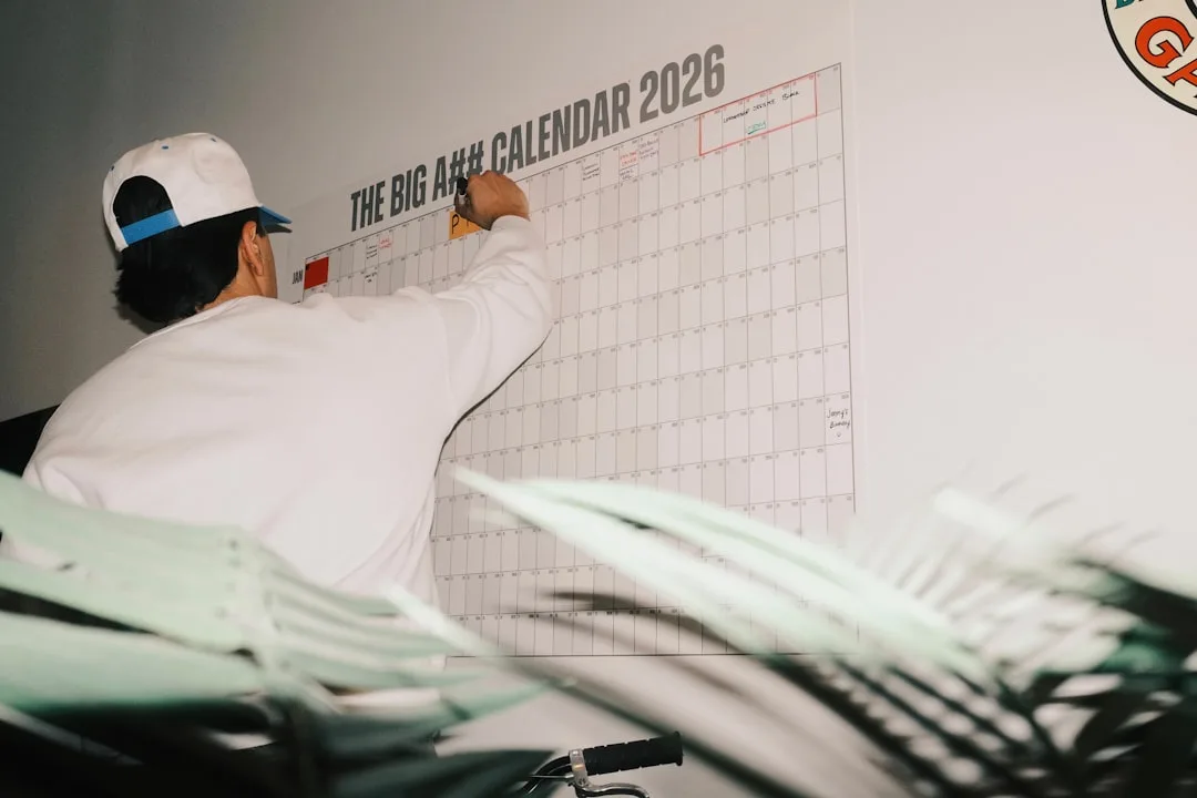 Timing en planning — Man writing on a large 2026 calendar